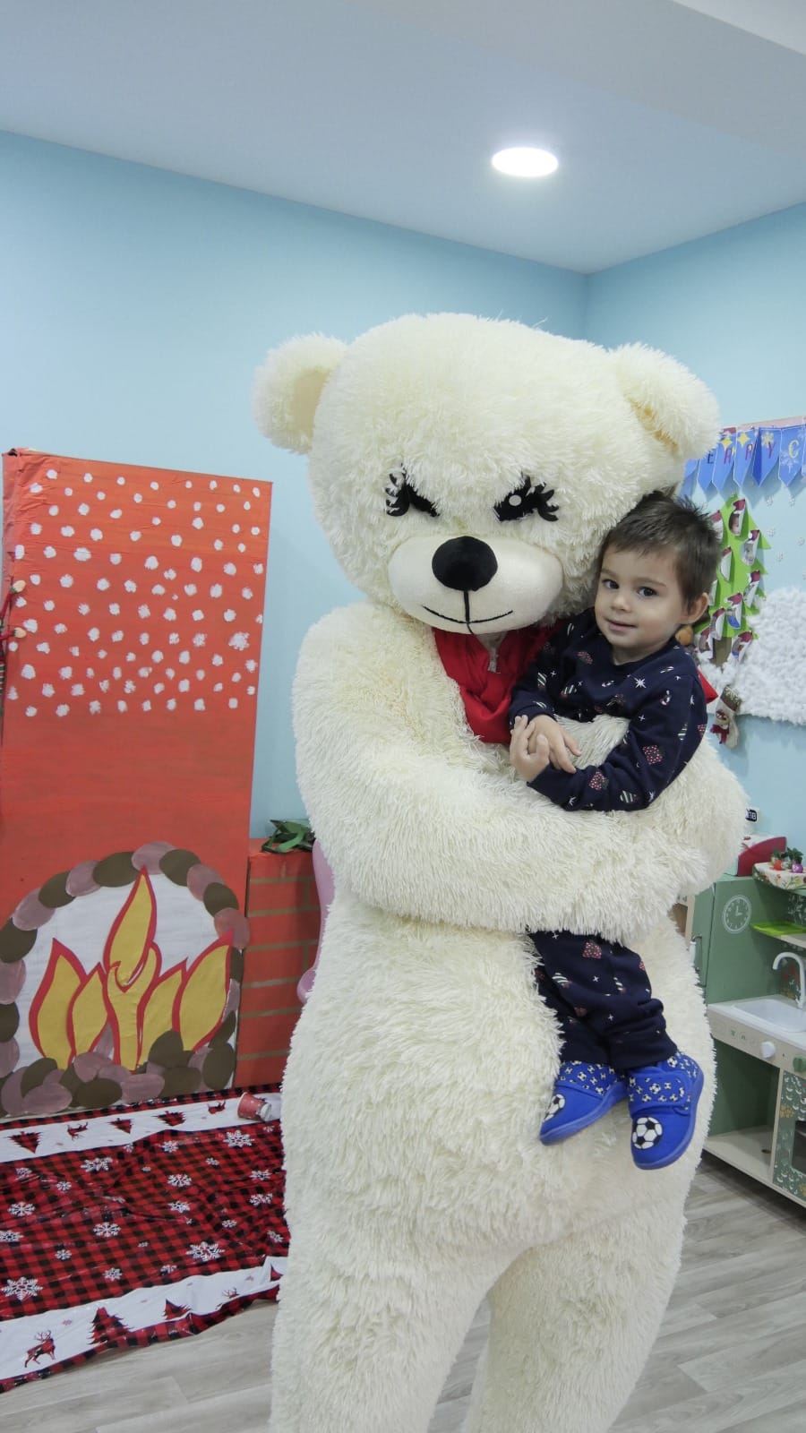 Child hugging a large teddy bear